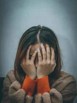 Frau erschöpft mit Händen vor dem Gesicht